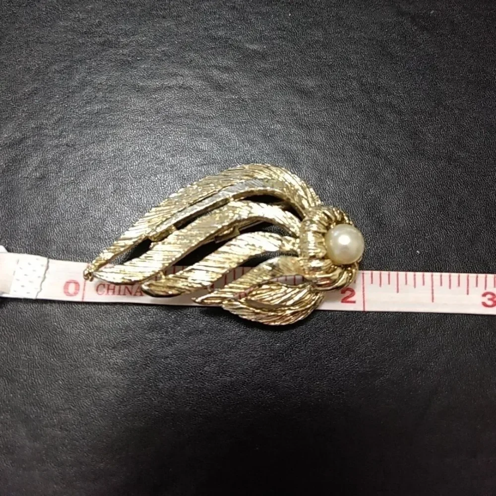 Gold tone brooch with faux pearl